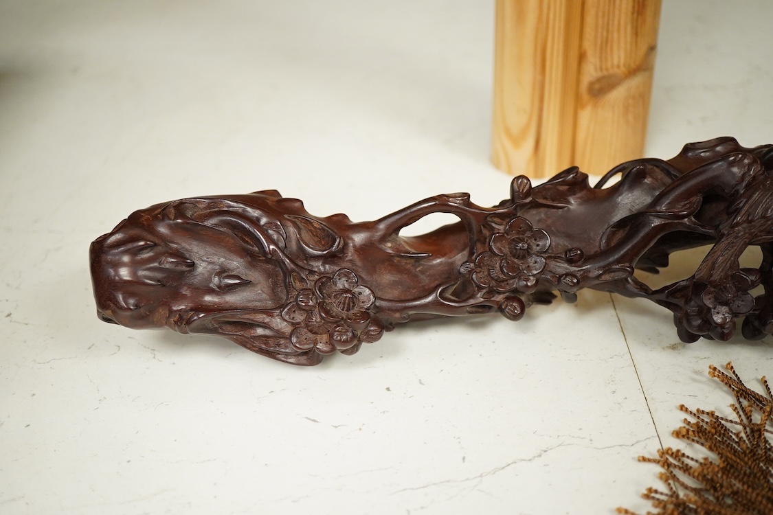 A Chinese carved hardwood Ruyi sceptre, with two porcelain ‘dragon’ beads, 50cm in length